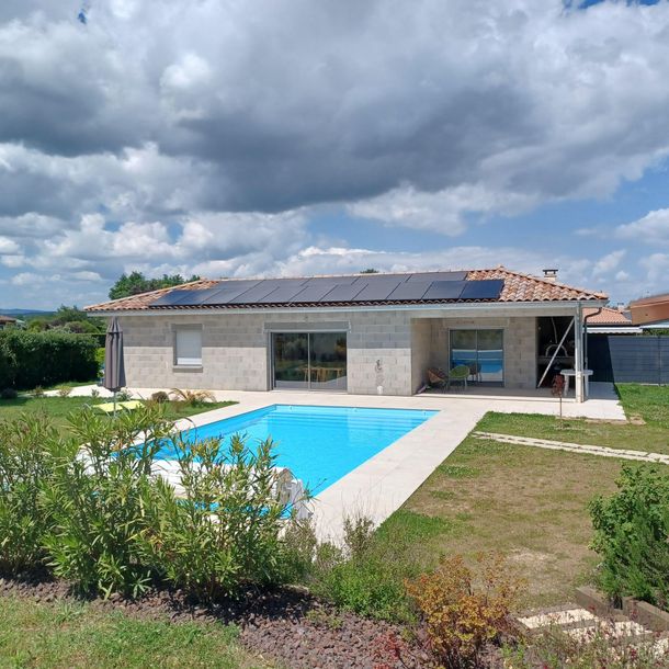 Maison avec piscine et panneaux solaires sur le toit.