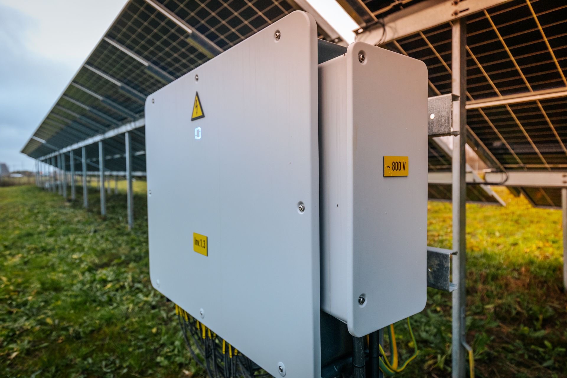 Boîtier électrique gris avec étiquettes d'avertissement jaunes fixées aux panneaux solaires.