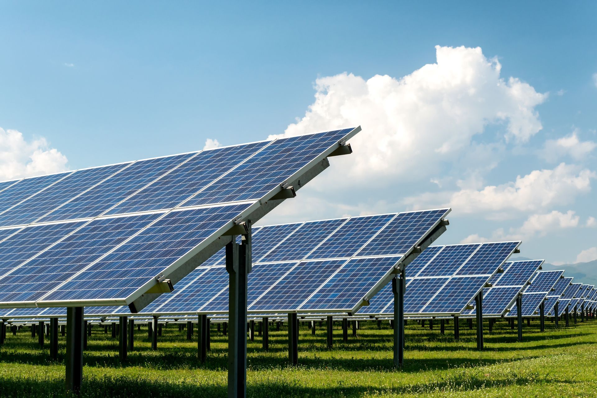 Des panneaux solaires dans un champ par une journée ensoleillée. Les panneaux bleus sont orientés vers le ciel.
