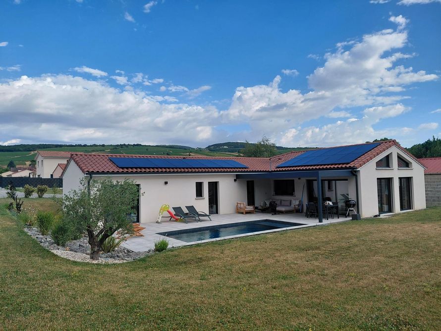 Des panneaux solaires installés sur le toit d'une maison, sous un ciel d'un bleu éclatant.