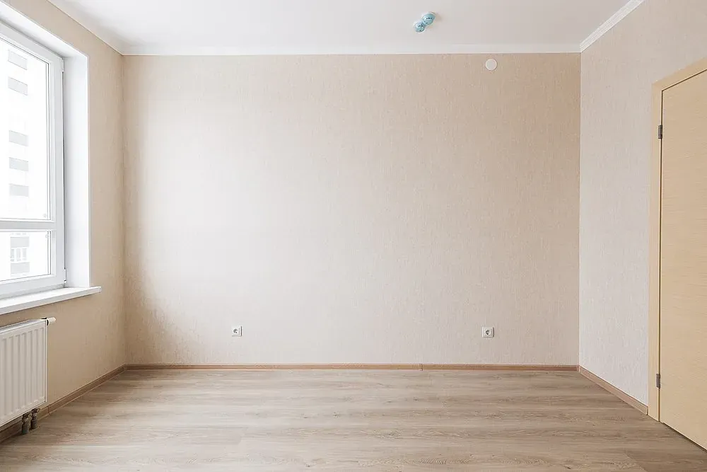Una habitación vacía con una ventana y un radiador.
