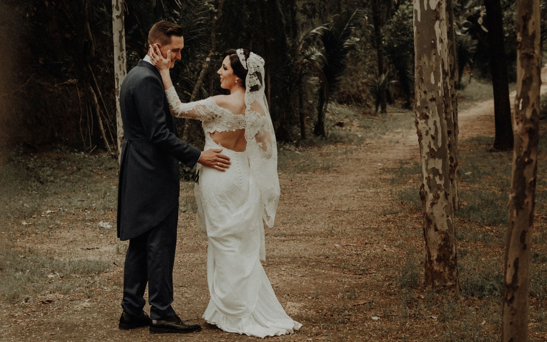 Una novia y un novio posan para una fotografía en el bosque.