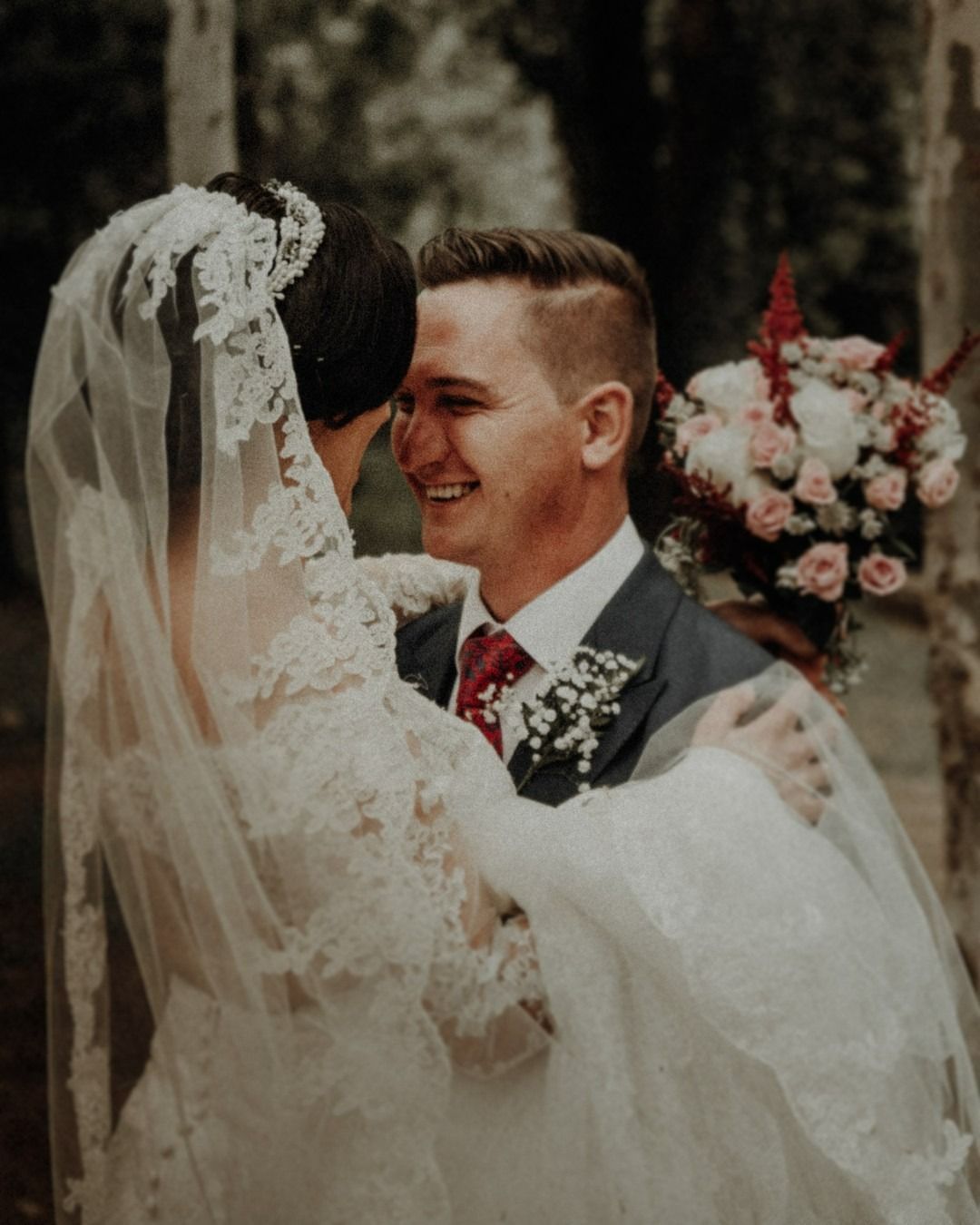 Una novia y un novio se miran y sonríen.