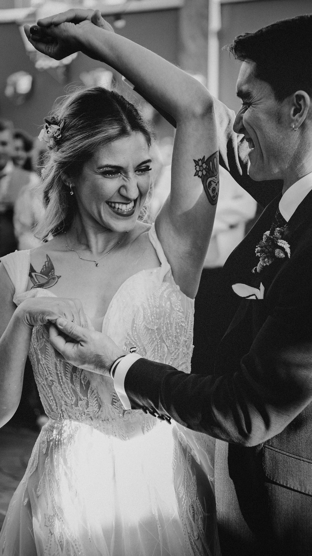 Una fotografía en blanco y negro de una novia y un novio bailando en la recepción de su boda.