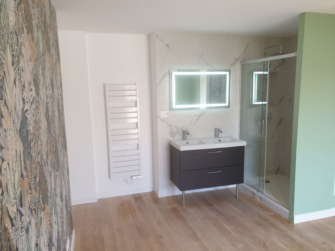 Pièce avec sol carrelé à motifs, portes grises et porte vitrée ouverte reflétant l'intérieur.