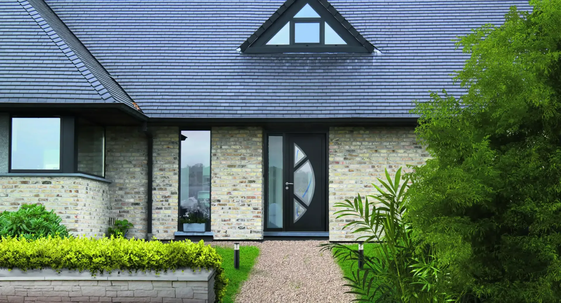 Façade de maison en pierre, toit en ardoise, porte d'entrée et chemin de galets y menant.