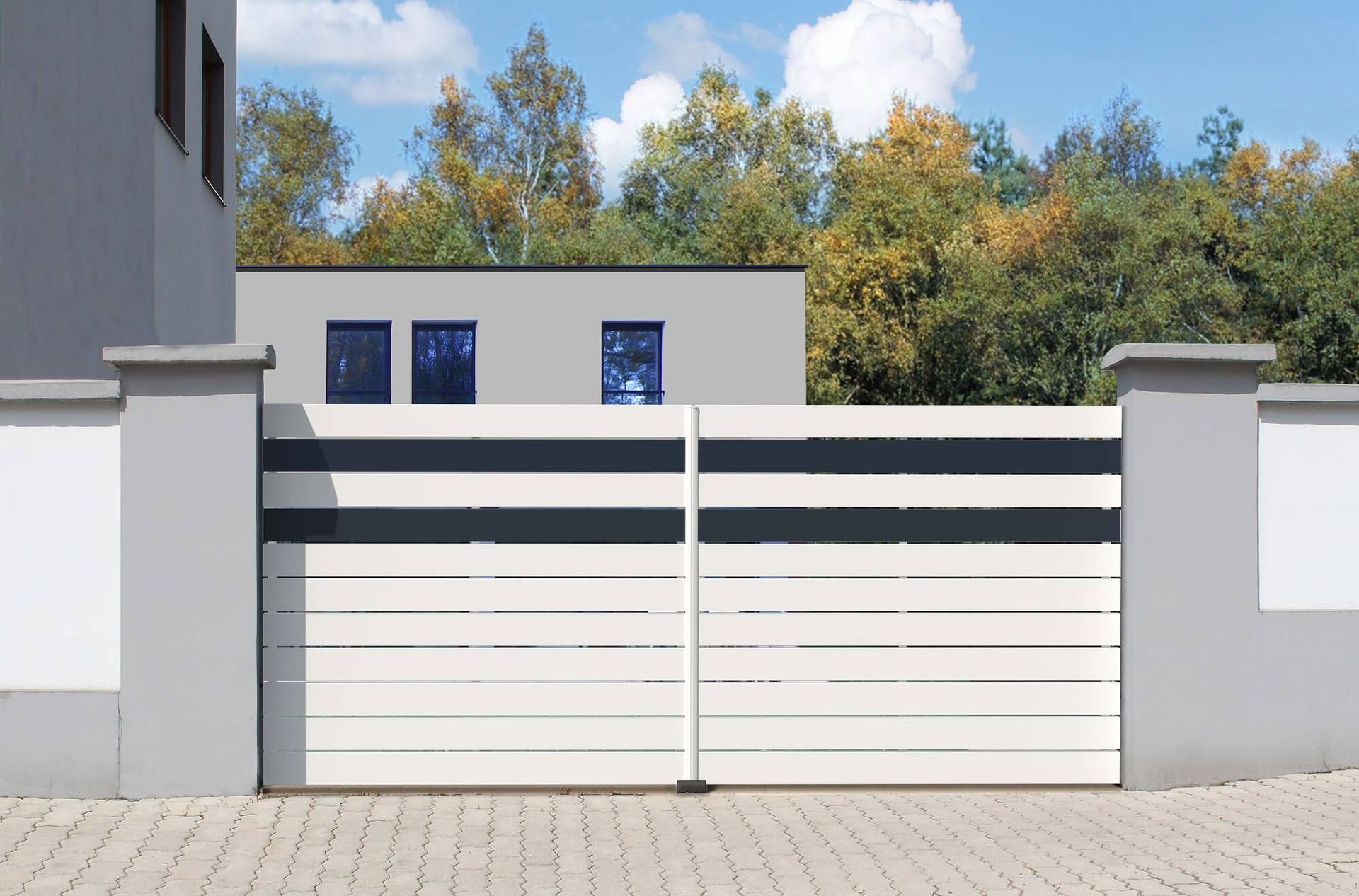 Portail blanc et gris à rayures gris foncé, flanqué de piliers gris, devant une maison moderne et des arbres.