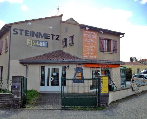 Bâtiment avec enseigne STEINMETZ, logo Solabrie. Façade avec bannière orange et portail ouvert.