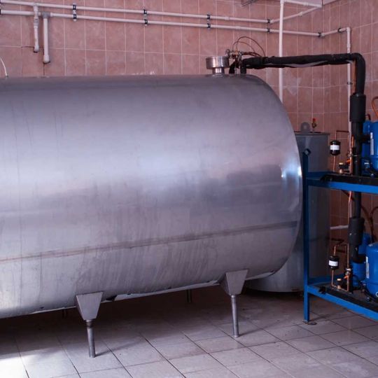 Un gran tanque de acero inoxidable se encuentra en una habitación.