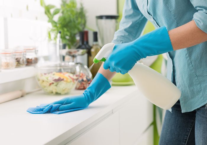 Femme nettoyant un meuble de cuisine