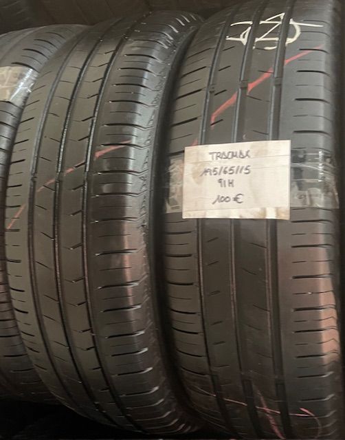 Dos neumáticos están apilados uno encima del otro y uno tiene una etiqueta con el precio.