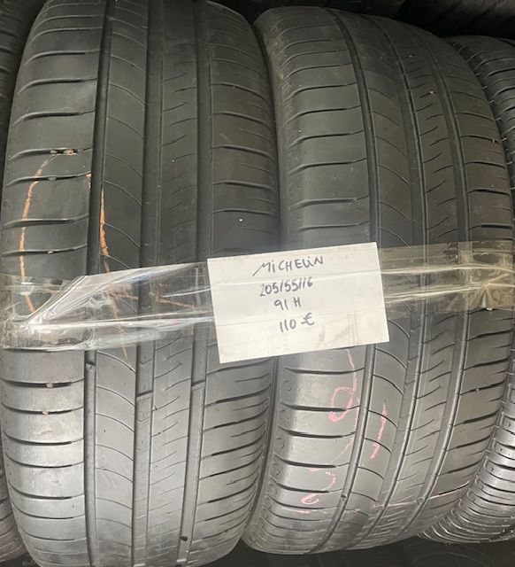 Un par de neumáticos Michelin están envueltos en plástico y apilados uno encima del otro.