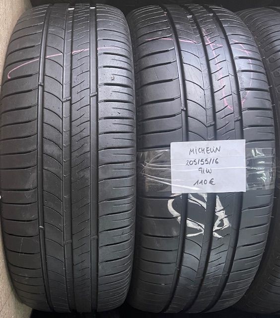 Un par de neumáticos Michelin están uno al lado del otro en un estante.