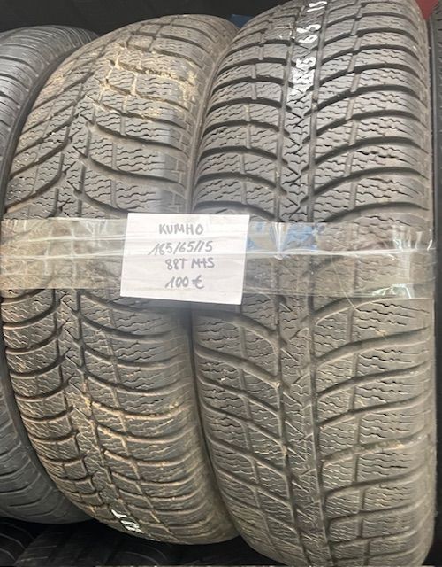 Un montón de neumáticos están apilados uno encima del otro en un estante.