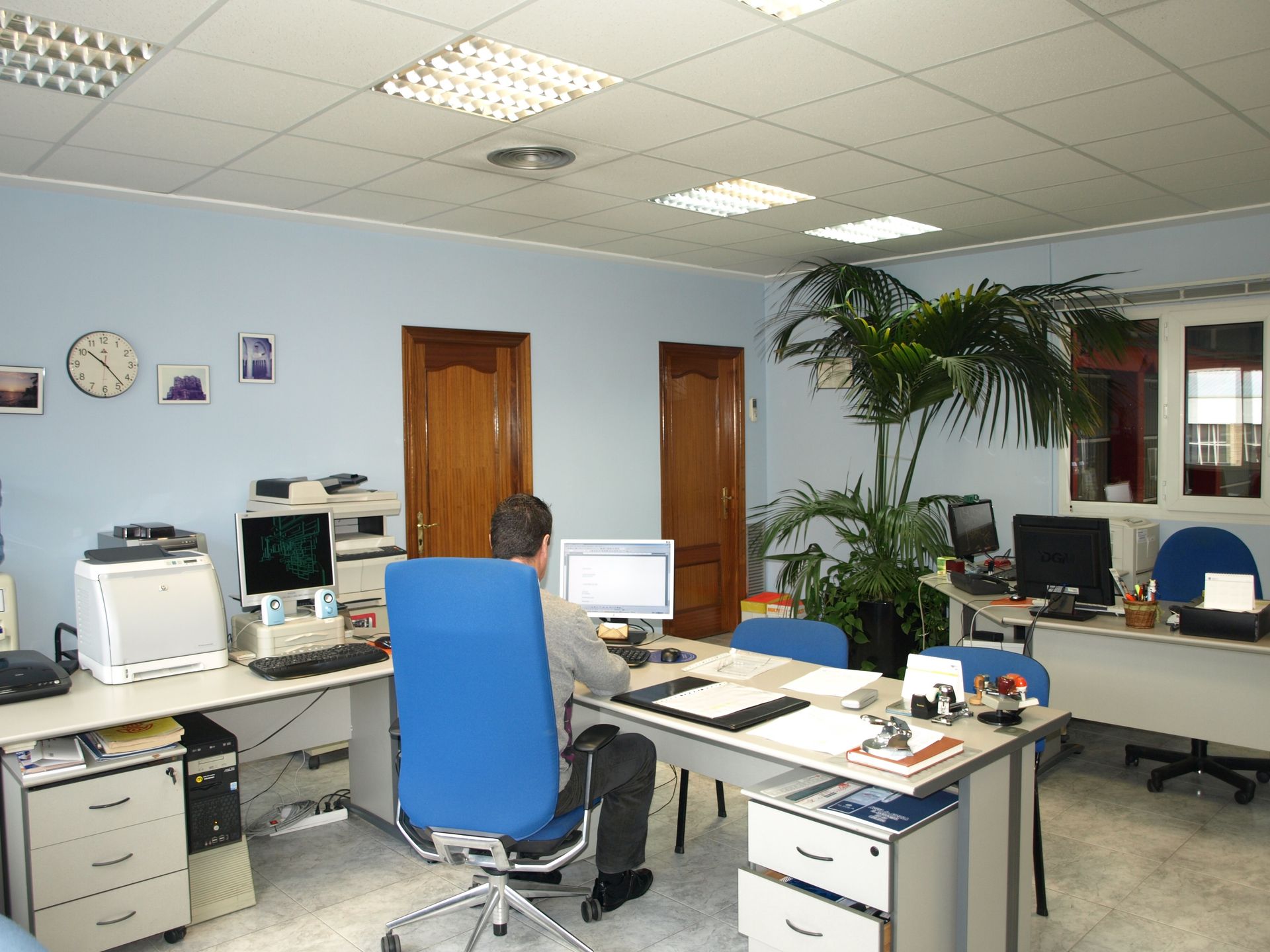 Un hombre se sienta en un escritorio con una computadora en una oficina.