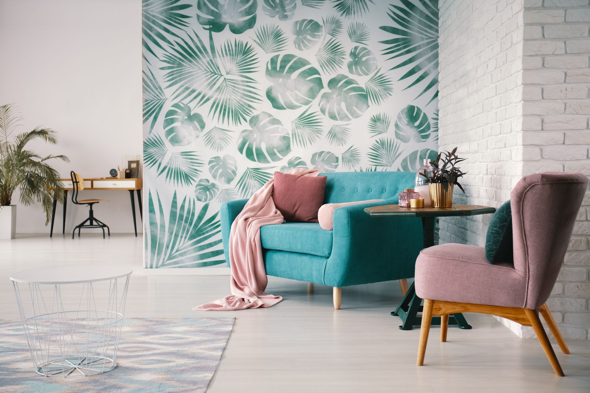 Salon moderne avec canapé bleu canard, fauteuil mauve, papier peint tropical et meubles en bois clair