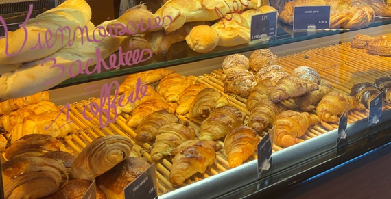 Vitrine de boulangerie avec croissants, pain et viennoiseries ; tons chaleureux.