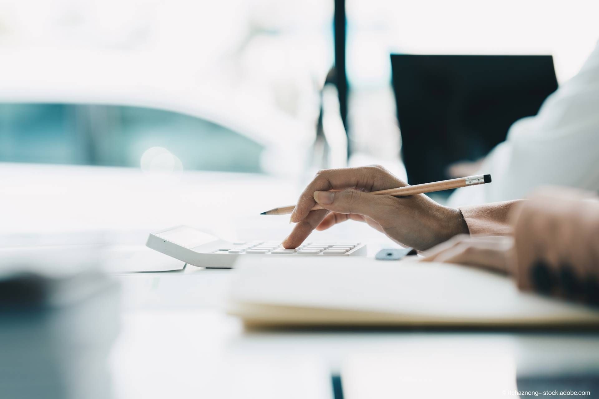 Ein Steuerberater rechnet etwas mit einem Taschenrechner