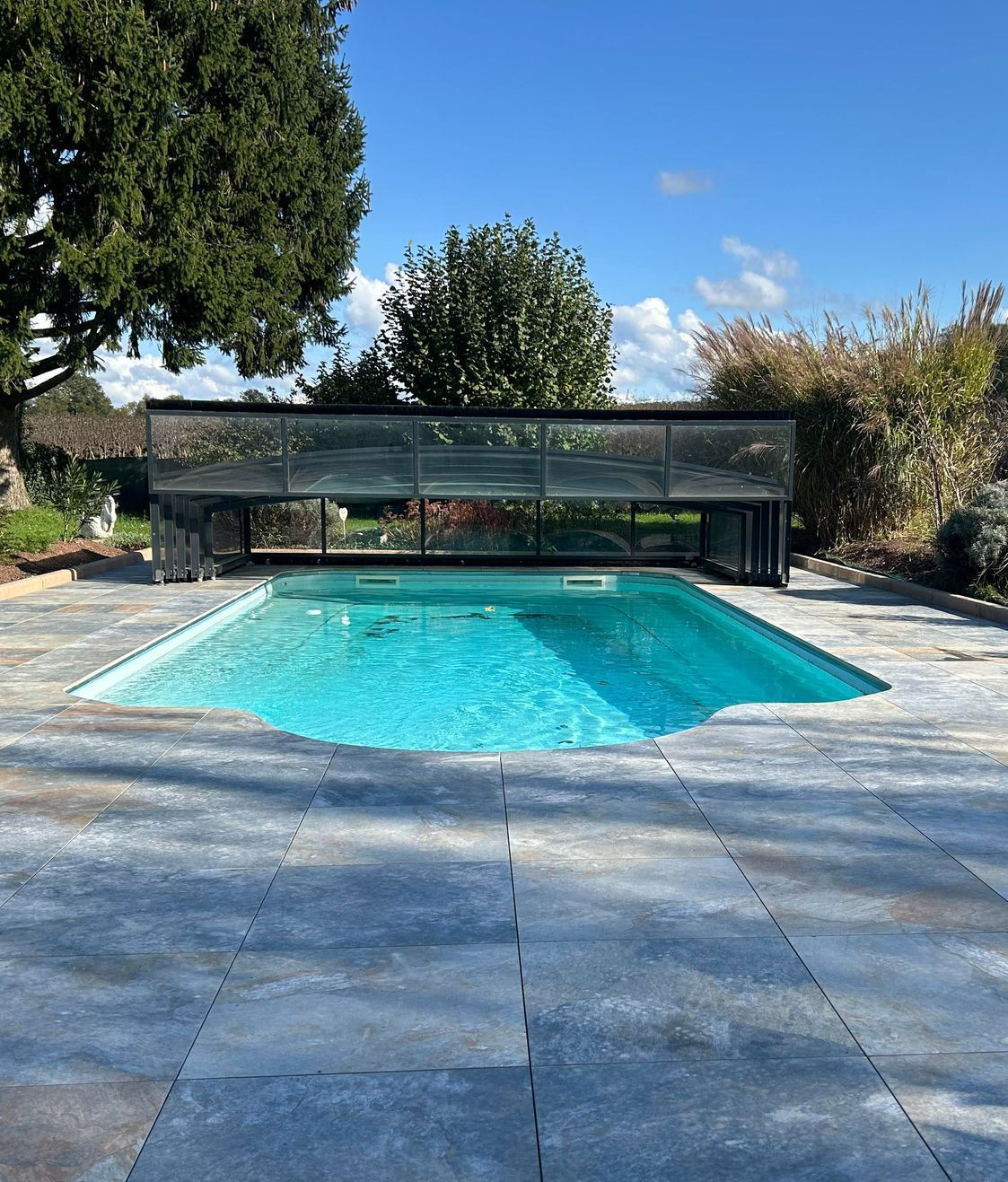 Une piscine avec une plage en carrelage antidérapant.