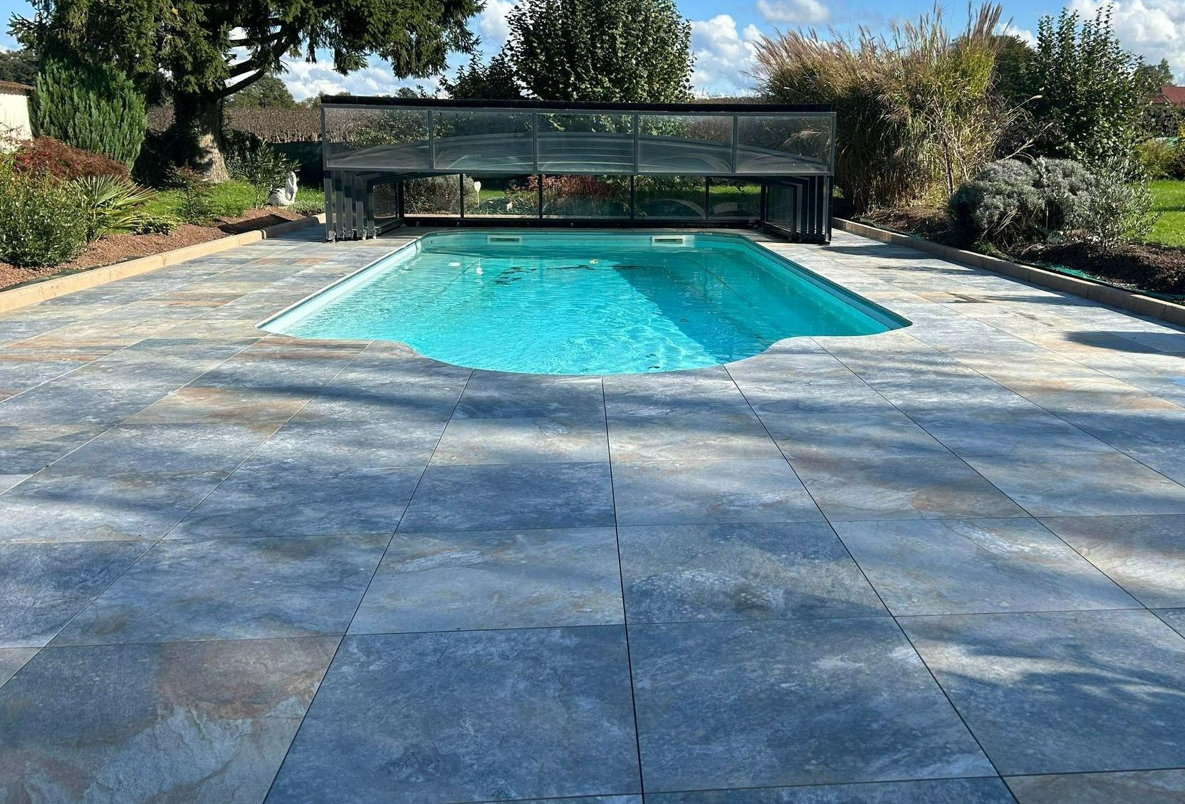 Une piscine couverte entourée d'un revêtement.