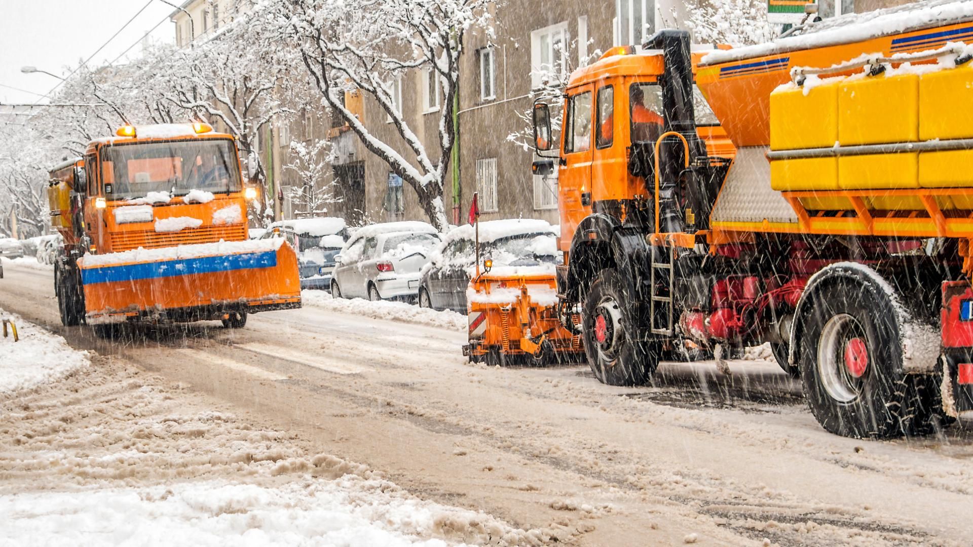 Zwei Schneepflüge räumen die Straße im Schnee.