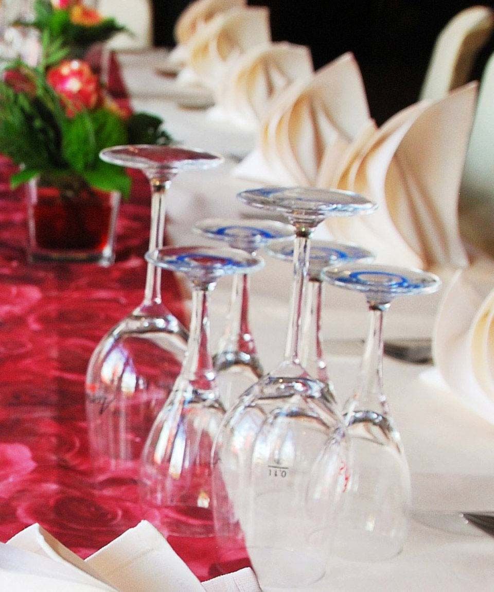 Weingläser auf dekorieten Tischreihen