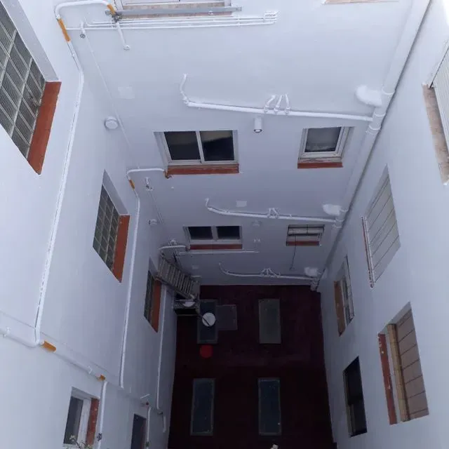 Mirando hacia el techo de un edificio con muchas ventanas