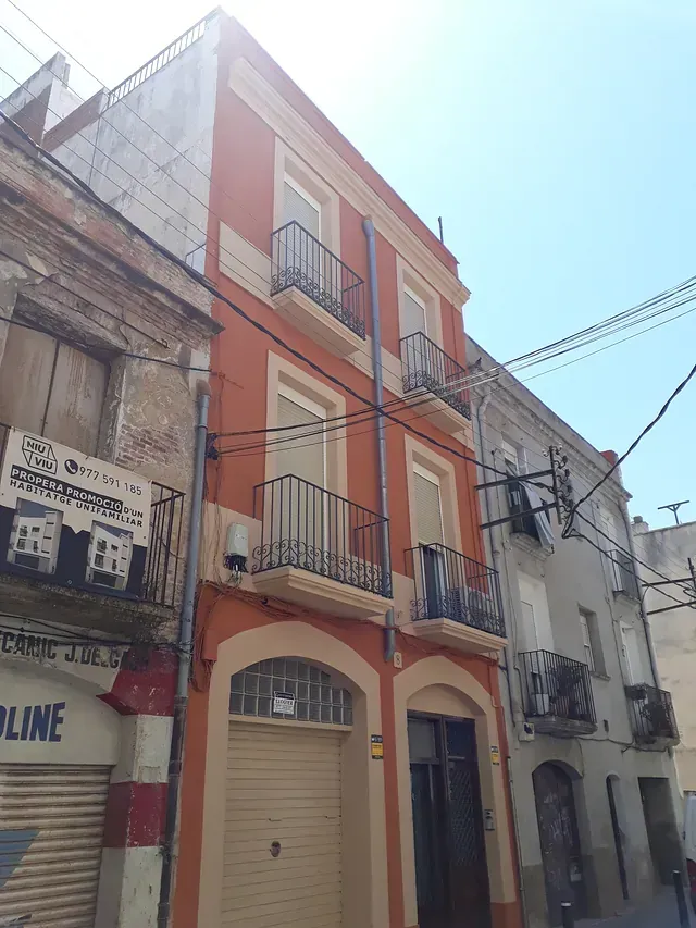 Un edificio con un balcón y un cartel que dice 'restaurante'.