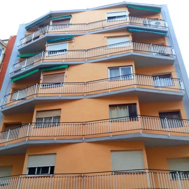 Un edificio con muchos balcones y persianas en las ventanas.