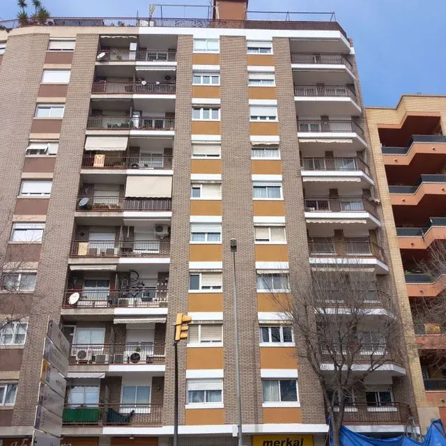 Un edificio de ladrillo con un cartel amarillo que dice Merkal.