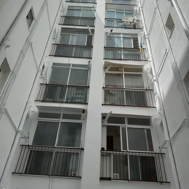 Un edificio alto con muchas ventanas y balcones.