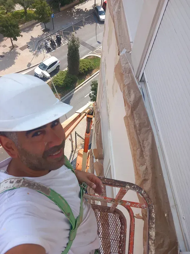 Un hombre que lleva un casco está de pie en un balcón.