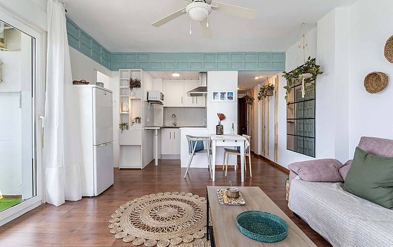 Fotografía del interior de un pequeño apartamento con cocina, sala de estar y balcón.