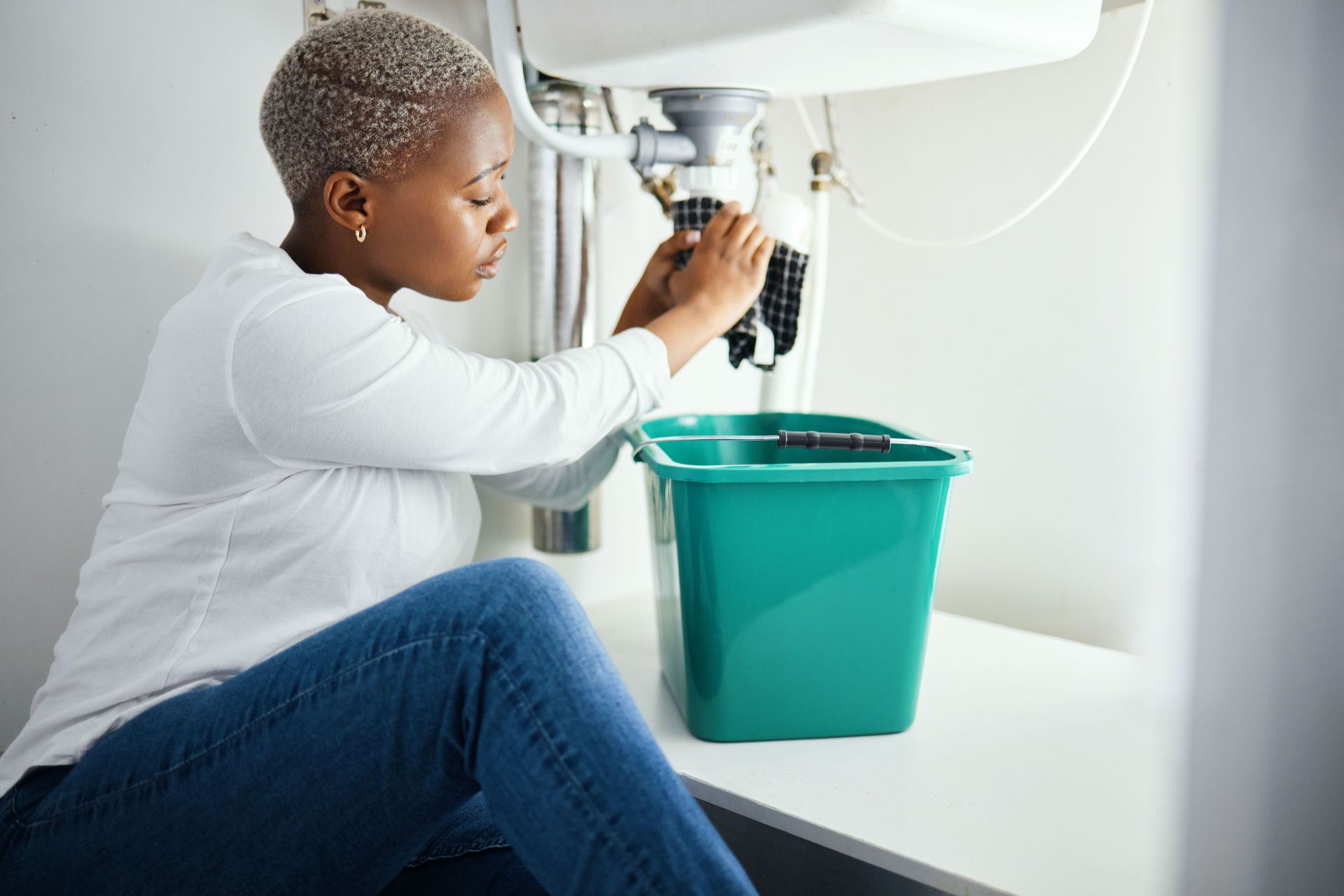 Femme qui a mit un seau sous son lavabo