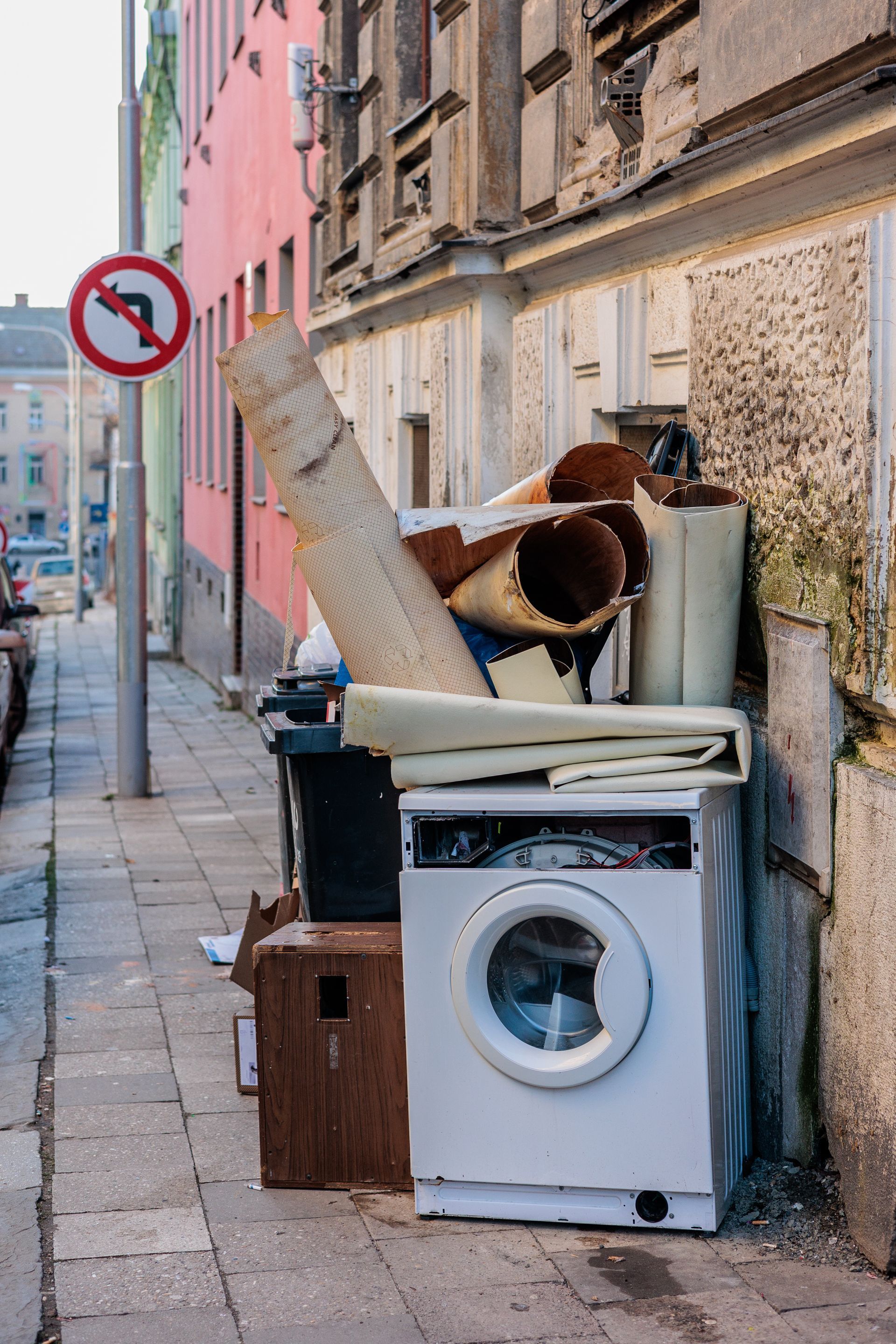 Des objets ménagers mis au rebut, notamment une machine à laver et des tapis roulés.