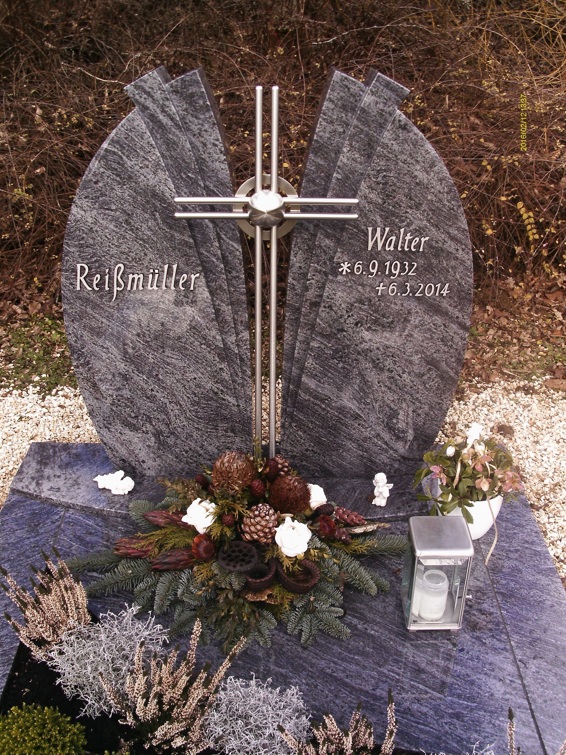 Ein Grab mit einem Kreuz und Blumen darauf