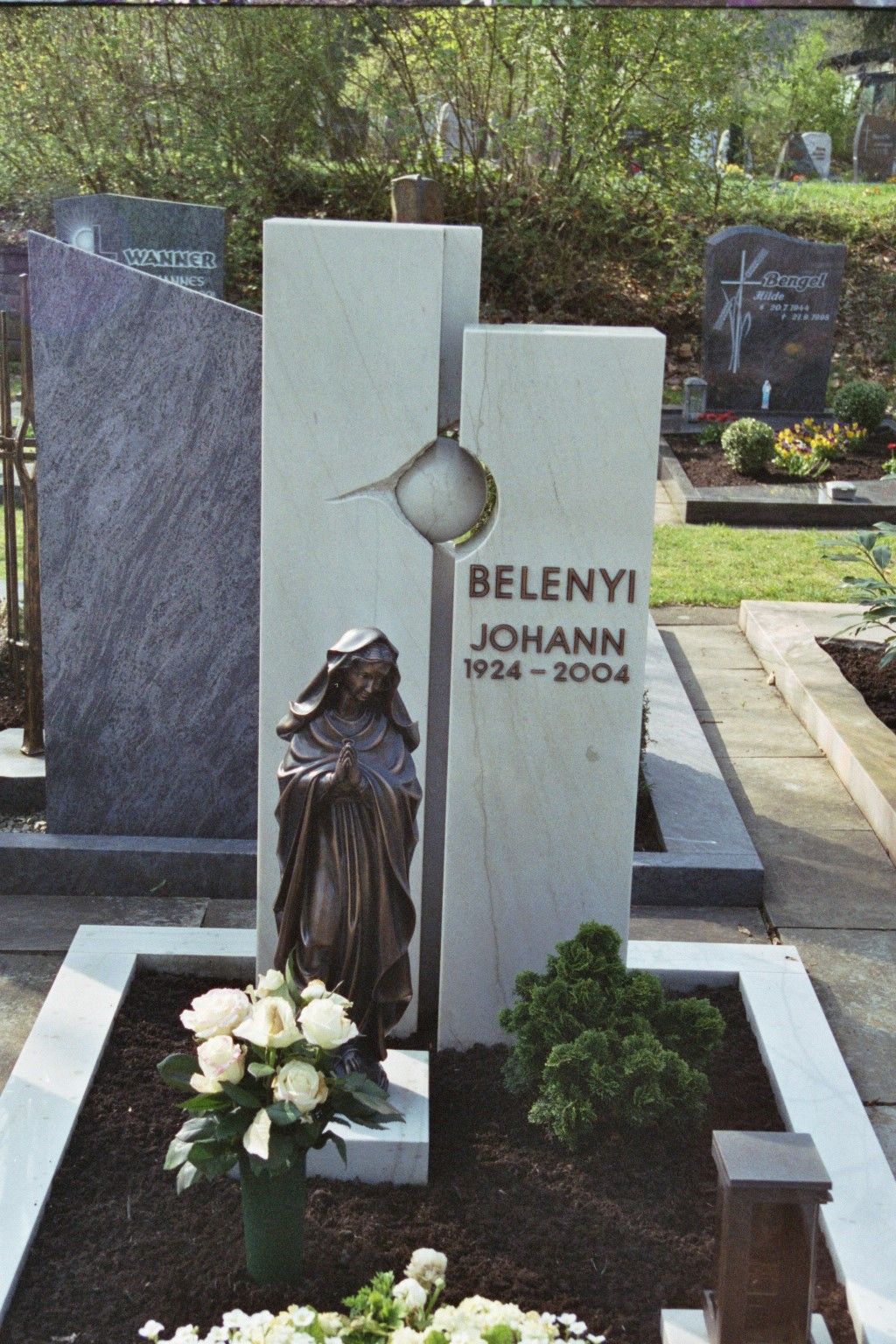 Ein Friedhof mit einer Frauenstatue und dem Namen Belenyi Johann