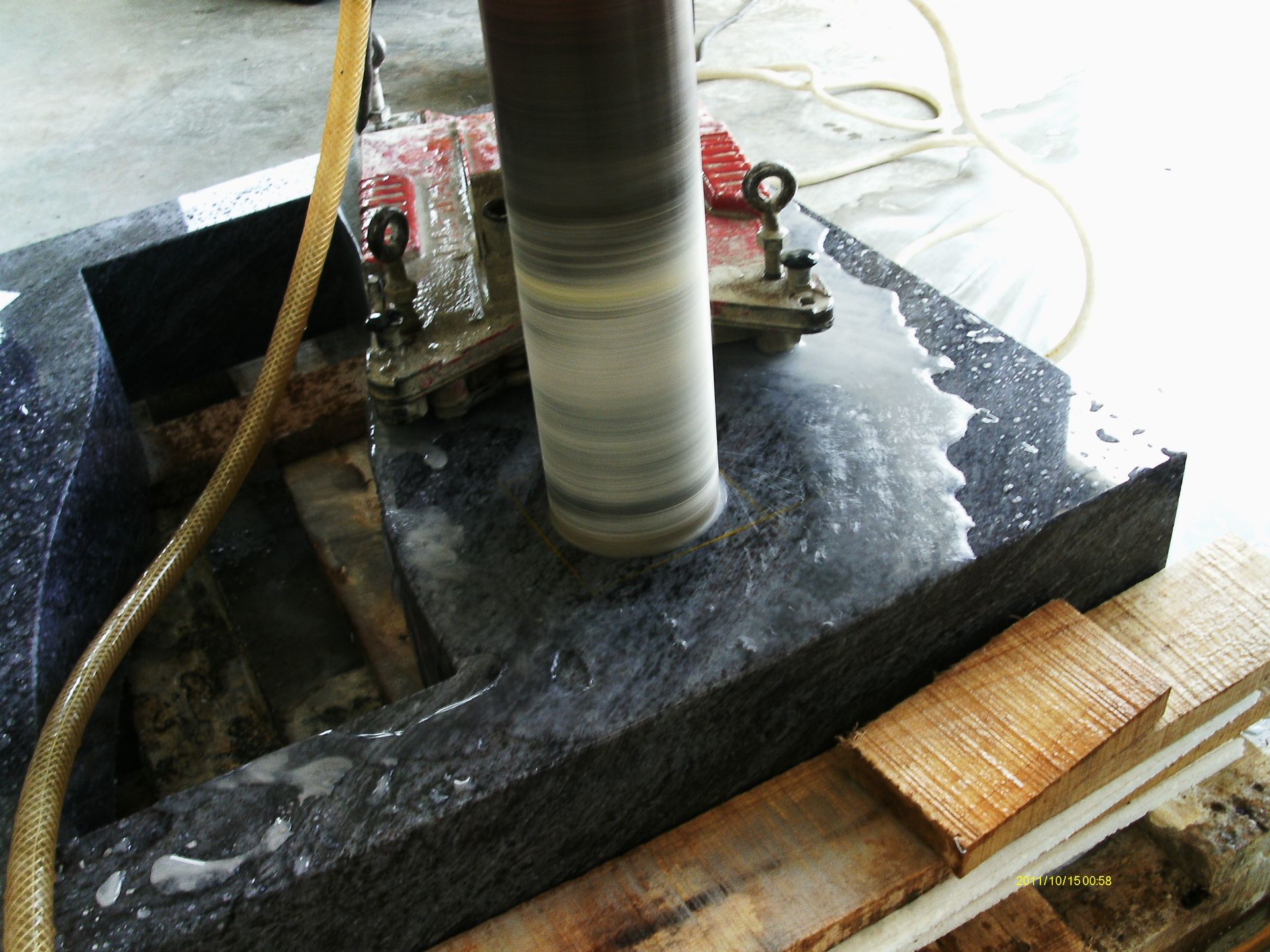 Eine Maschine schneidet ein Loch in ein Stück Granit