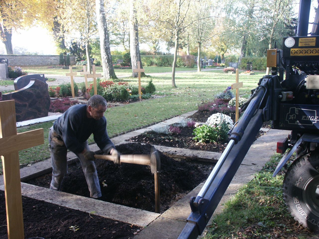 Ein Mann gräbt ein Grab auf einem Friedhof