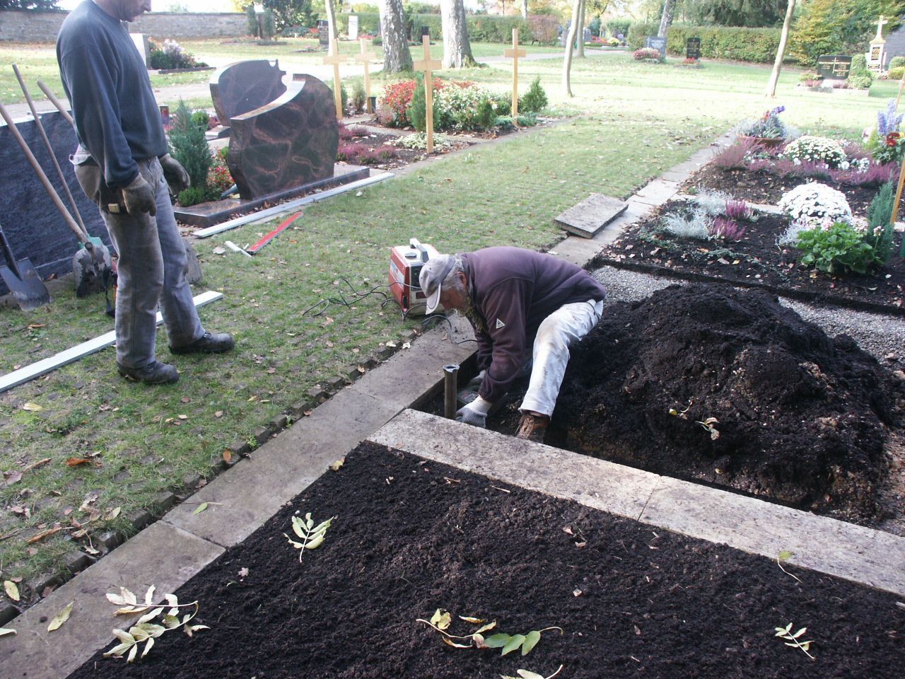 Ein Mann gräbt ein Grab auf einem Friedhof