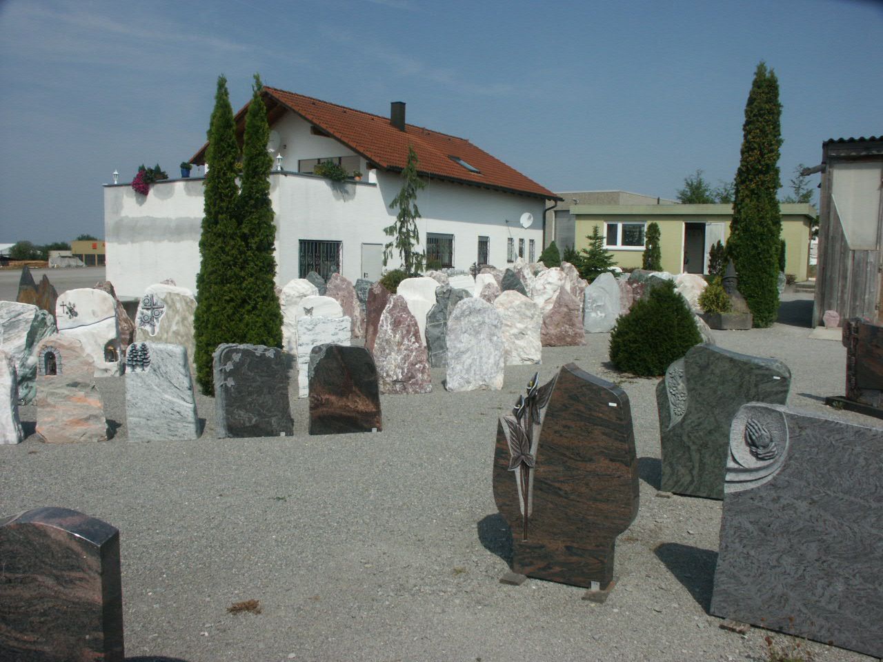Ein Friedhof mit vielen Gräbern und einem Haus im Hintergrund