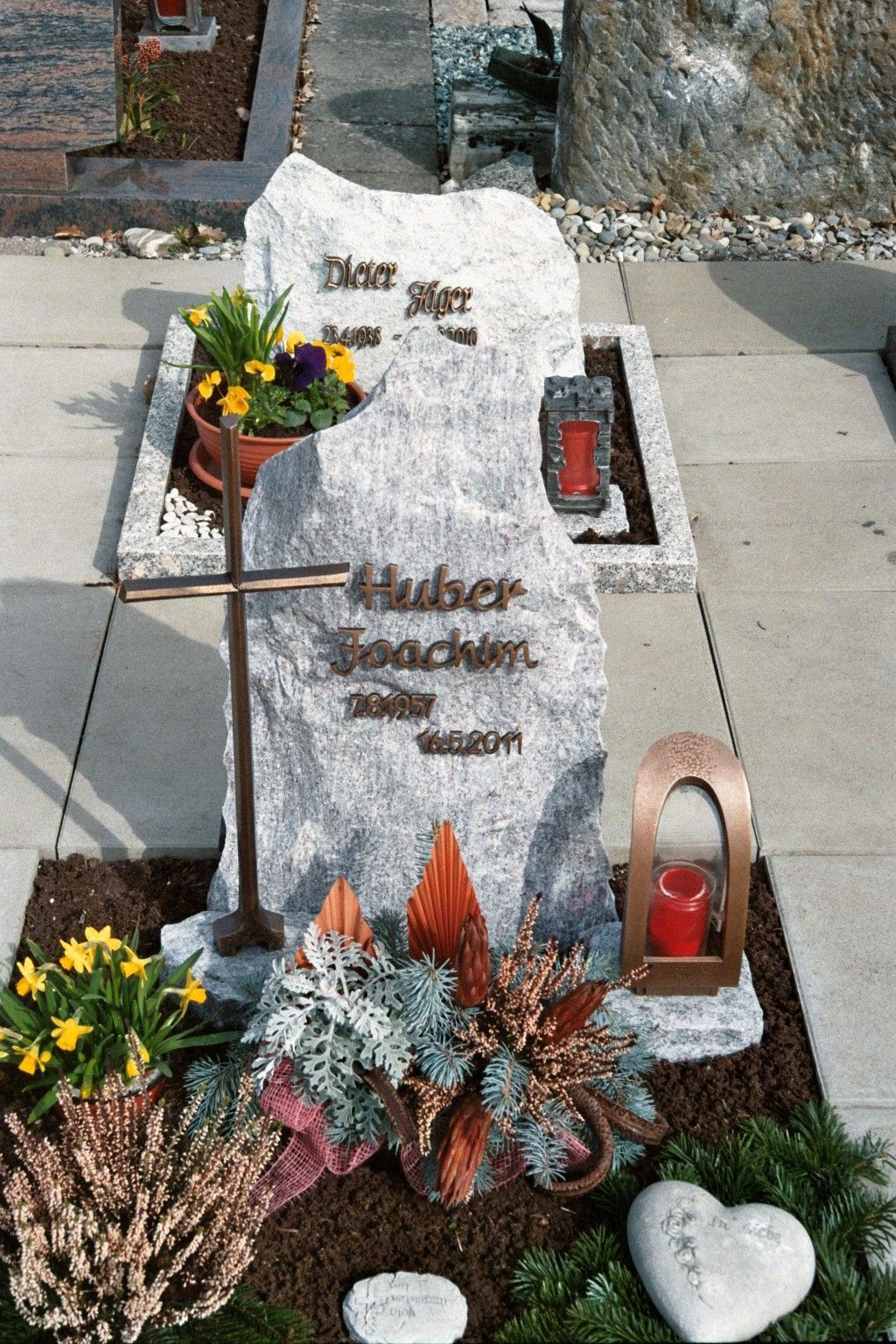 Ein Grab auf einem Friedhof mit Blumen und einer Kerze