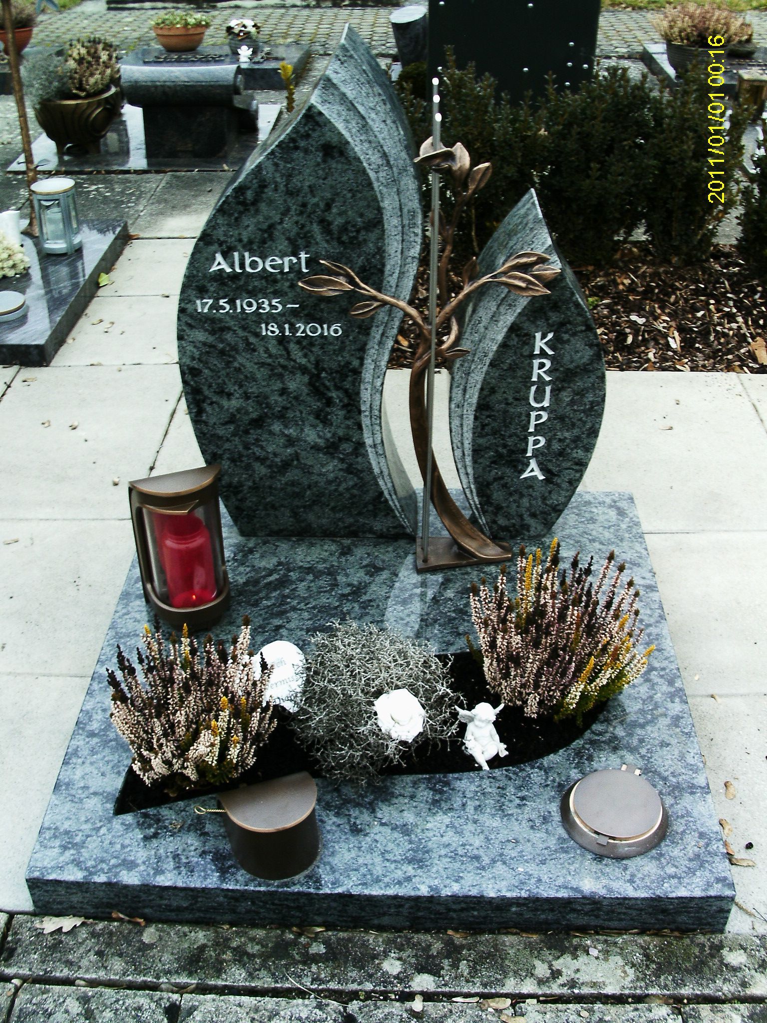 Ein Grab mit einer Kerze und Blumen darauf