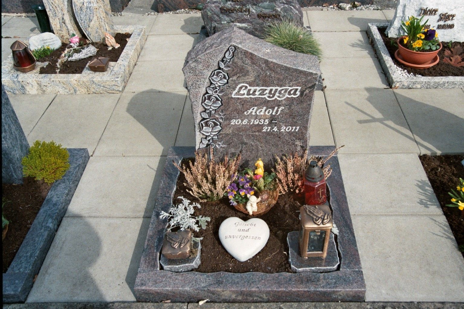 Ein Grab auf einem Friedhof mit einem Herzen und Kerzen