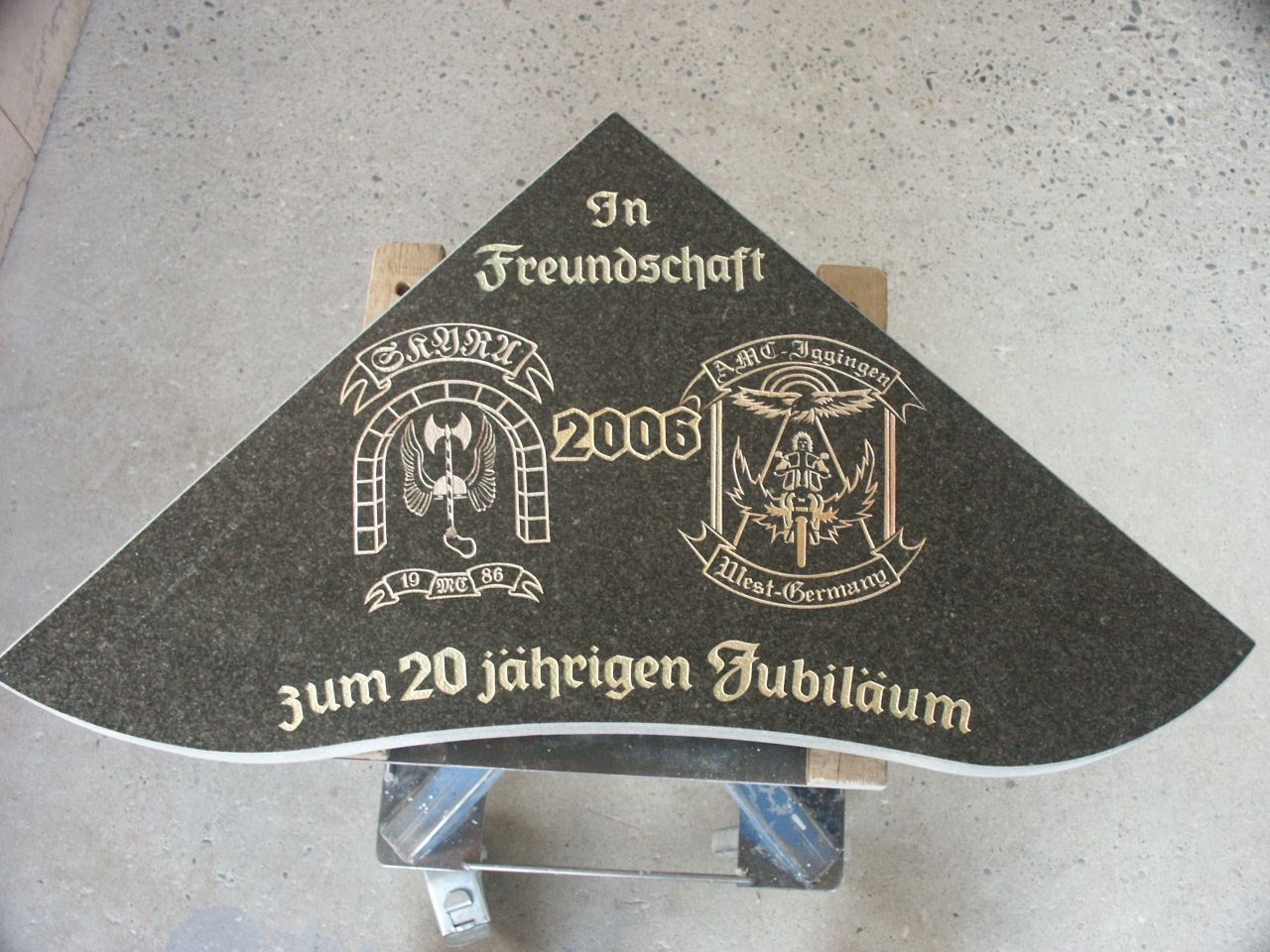 Gedenkplatte zum Jubiläum zweier Vereine mit den jeweiligen Wappen bzw. Logos.