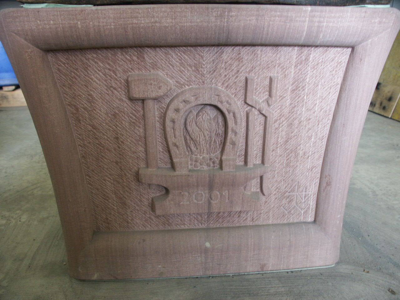 Der Sandsteinunterbau eines Ambosses mit dem Symbol vom Schmied