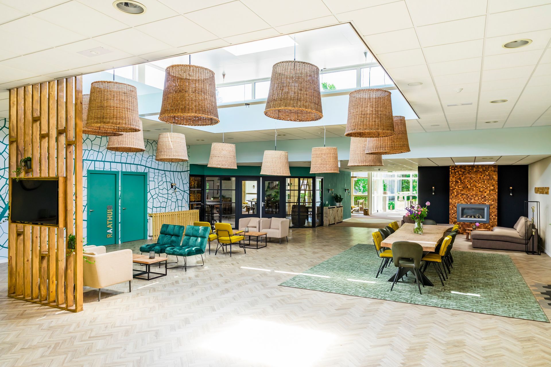 Houten insectenhotel in een tuin, omgeven door een rustieke schutting en groen, met bomen op de achtergrond.