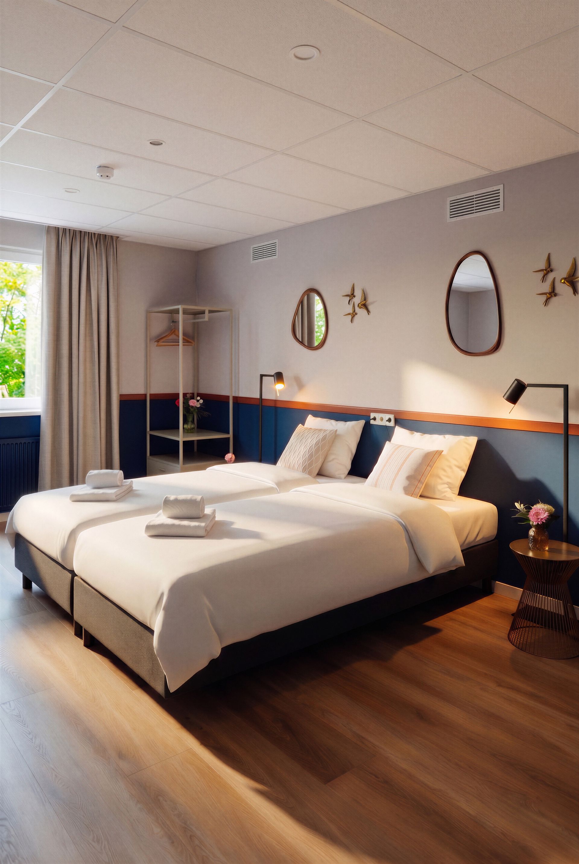 Vogelhuisje en bed met kussens met patronen tegen een lichtgroene muur, klein tafeltje met bloemen.