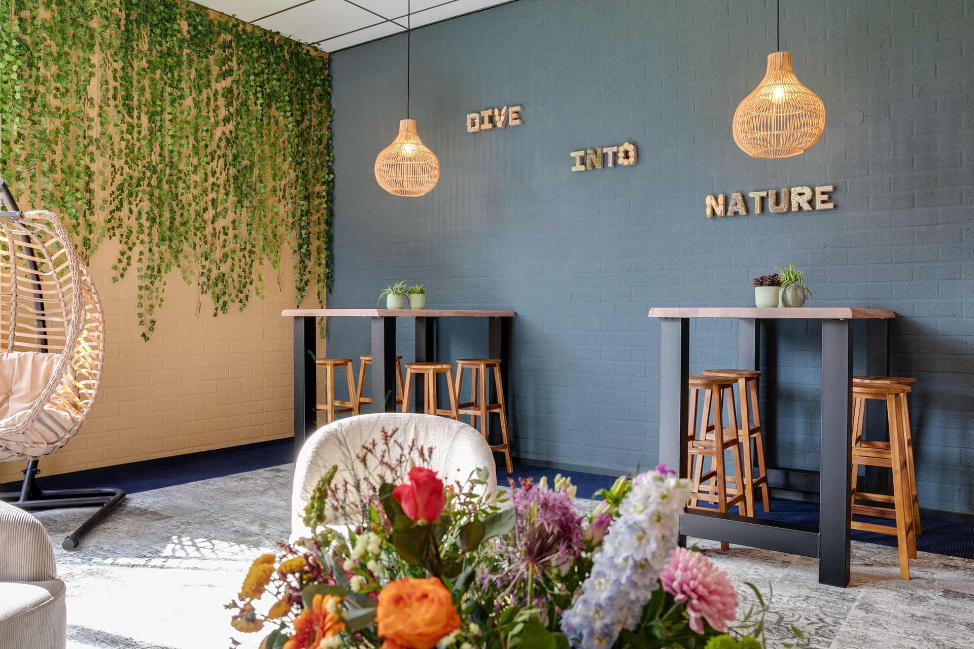 Gezellige lounge met hangplanten, rotanlampen, houten tafels en wanddecoratie met het thema 