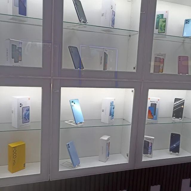 Una vitrina llena de una variedad de teléfonos móviles y cajas.